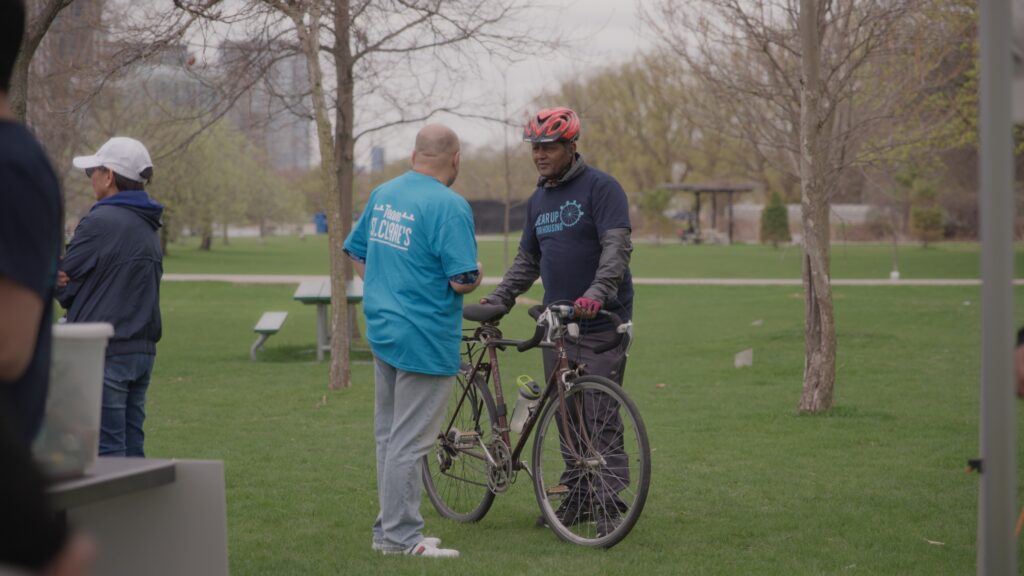 Two people talking between a bike.